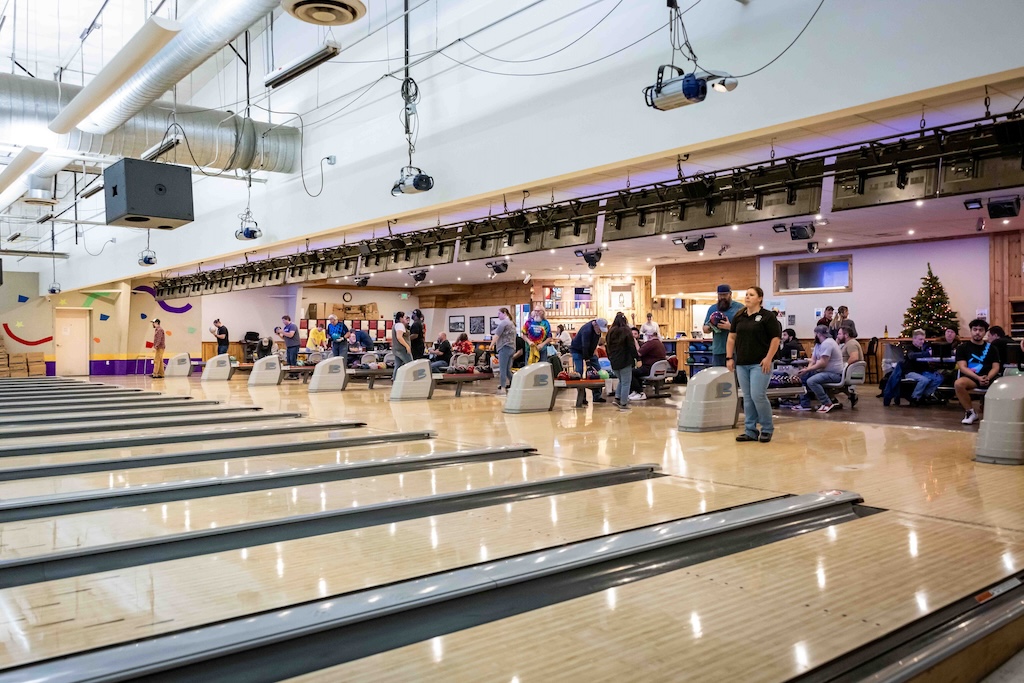 Zeppoz bowling lanes with bowlers during a league getting ready to bowl and others sitting at the seating area. 